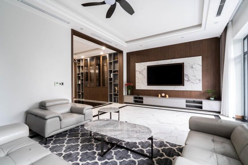 Đây là công trình thi công hoàn thiện nội thất khu vực phòng khách biệt thự 4 tầng tại nghệ an. Phía đối diện bộ sofa bọc da hiện đại cao cấp chính là khu vực tivi. Tại khu vực tường tivi biệt thự này, Morehome sử dụng 2 vật liệu để trang trí cho nội thất biệt thự, đó chính là: gỗ ốp tường và đá nhân tạo vân mây ốp tường.